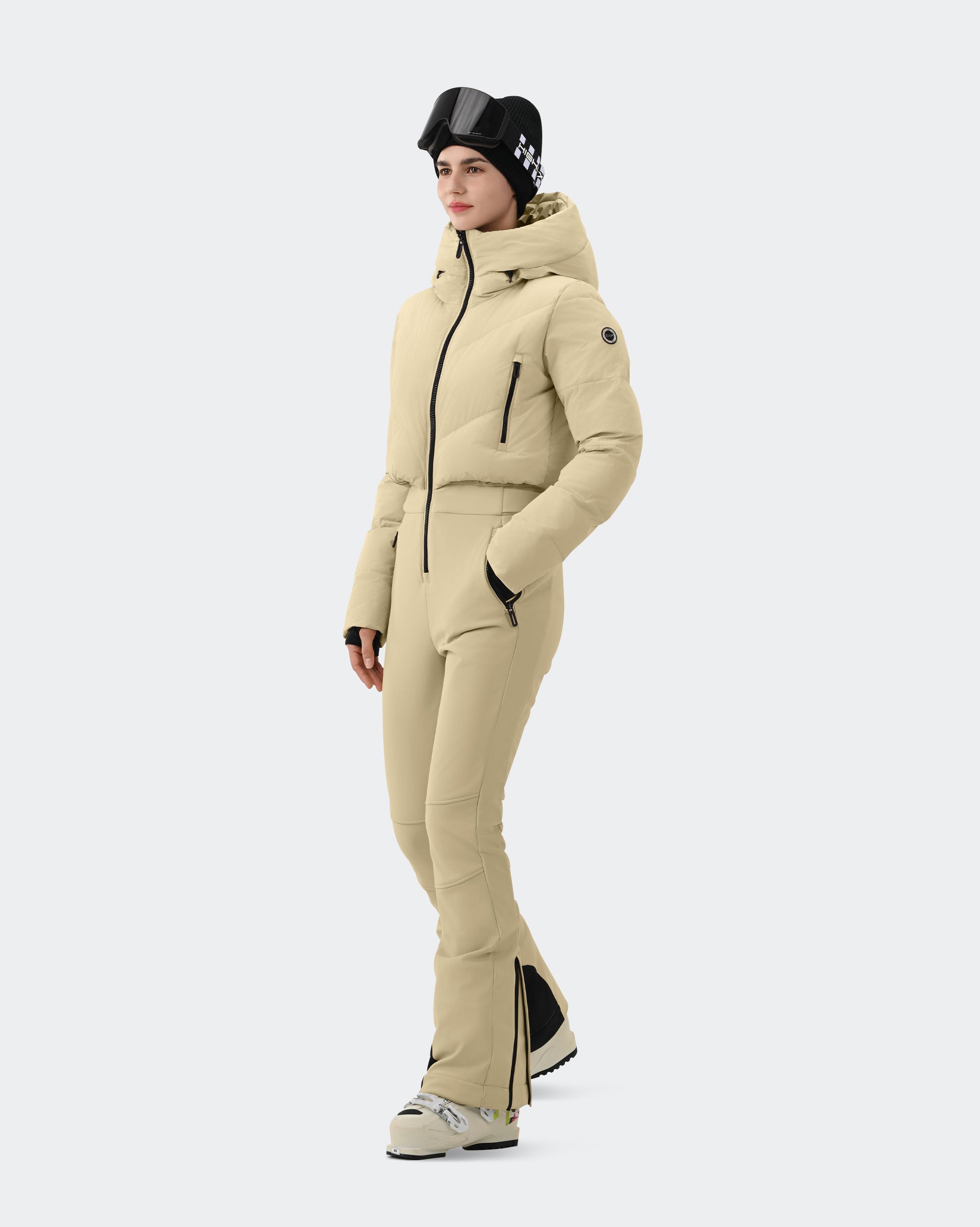 Woman wearing Light Khaki one-piece insulated ski suit outdoor lifestyle shot
