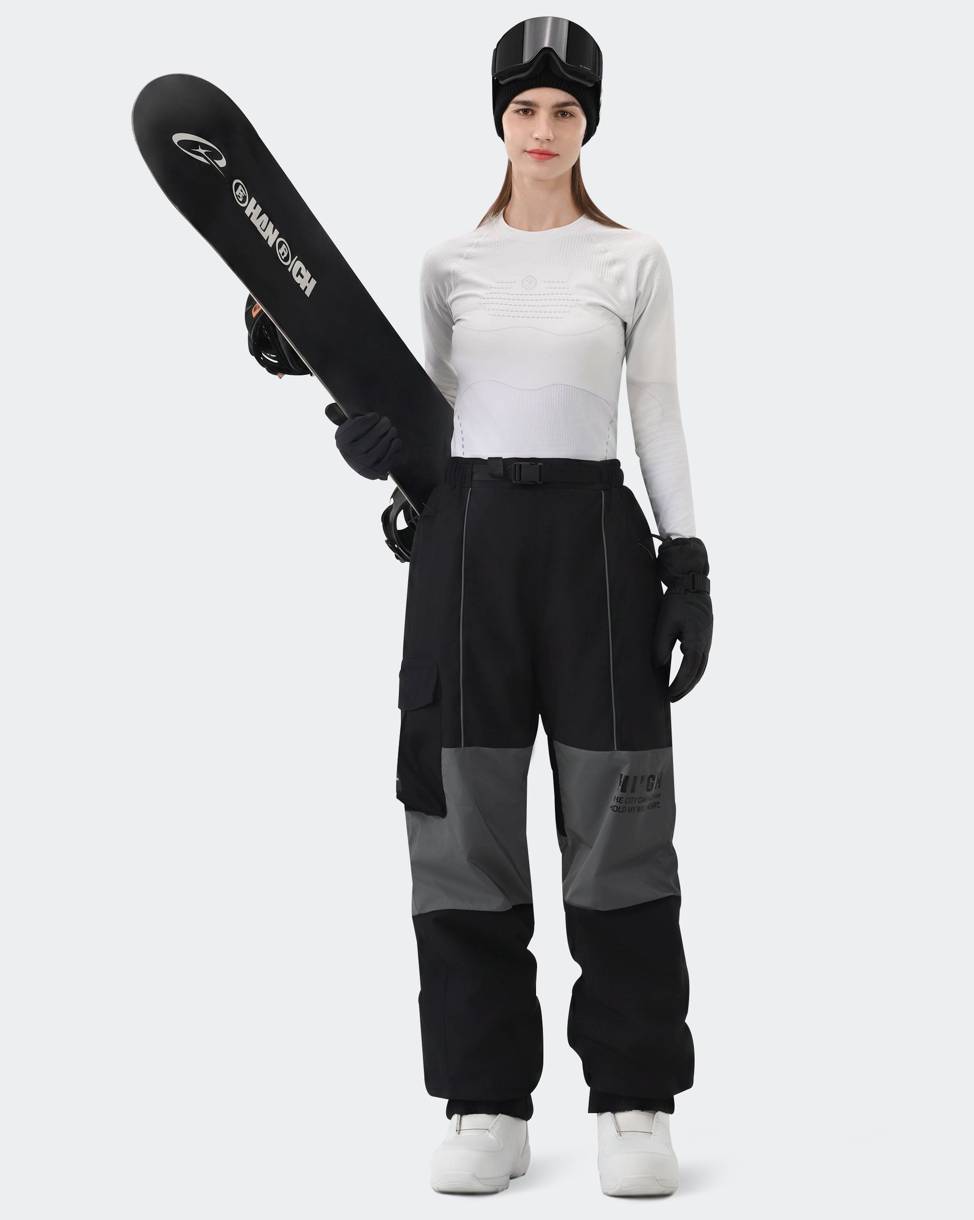 HIGH EXPERIENCE Women's Baggy Ski Pants Black On Model with Board — Waterproof Snowboard Pants