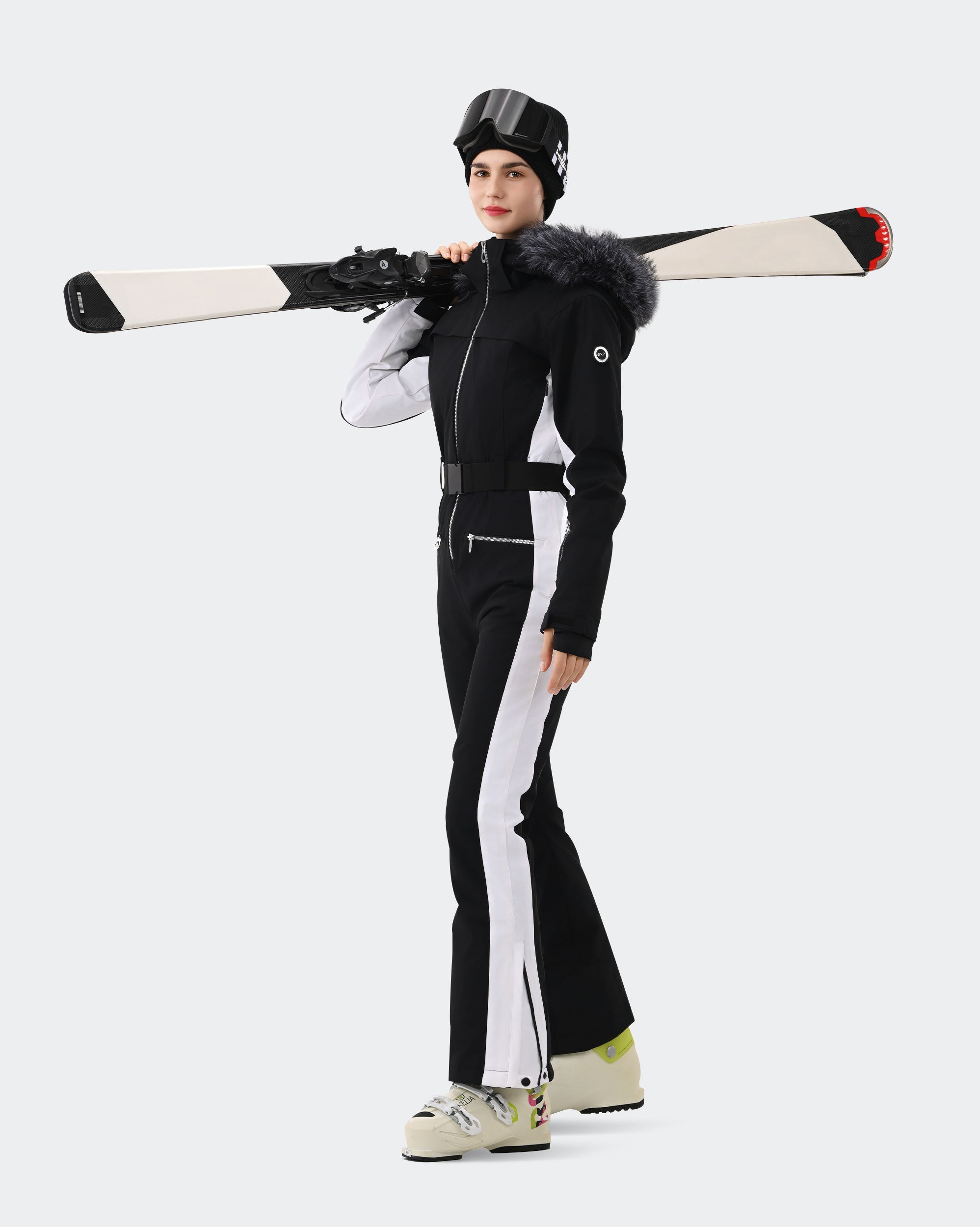 Women wearing Black White one-piece waterproof ski suit on slopes
